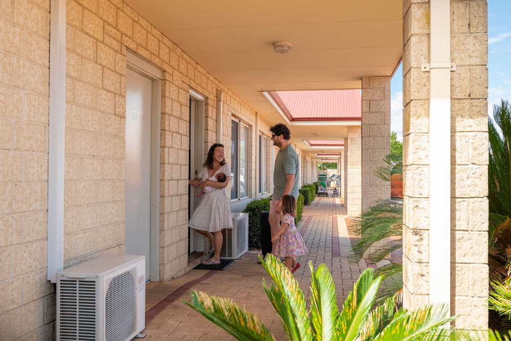 A family walking into a motel room