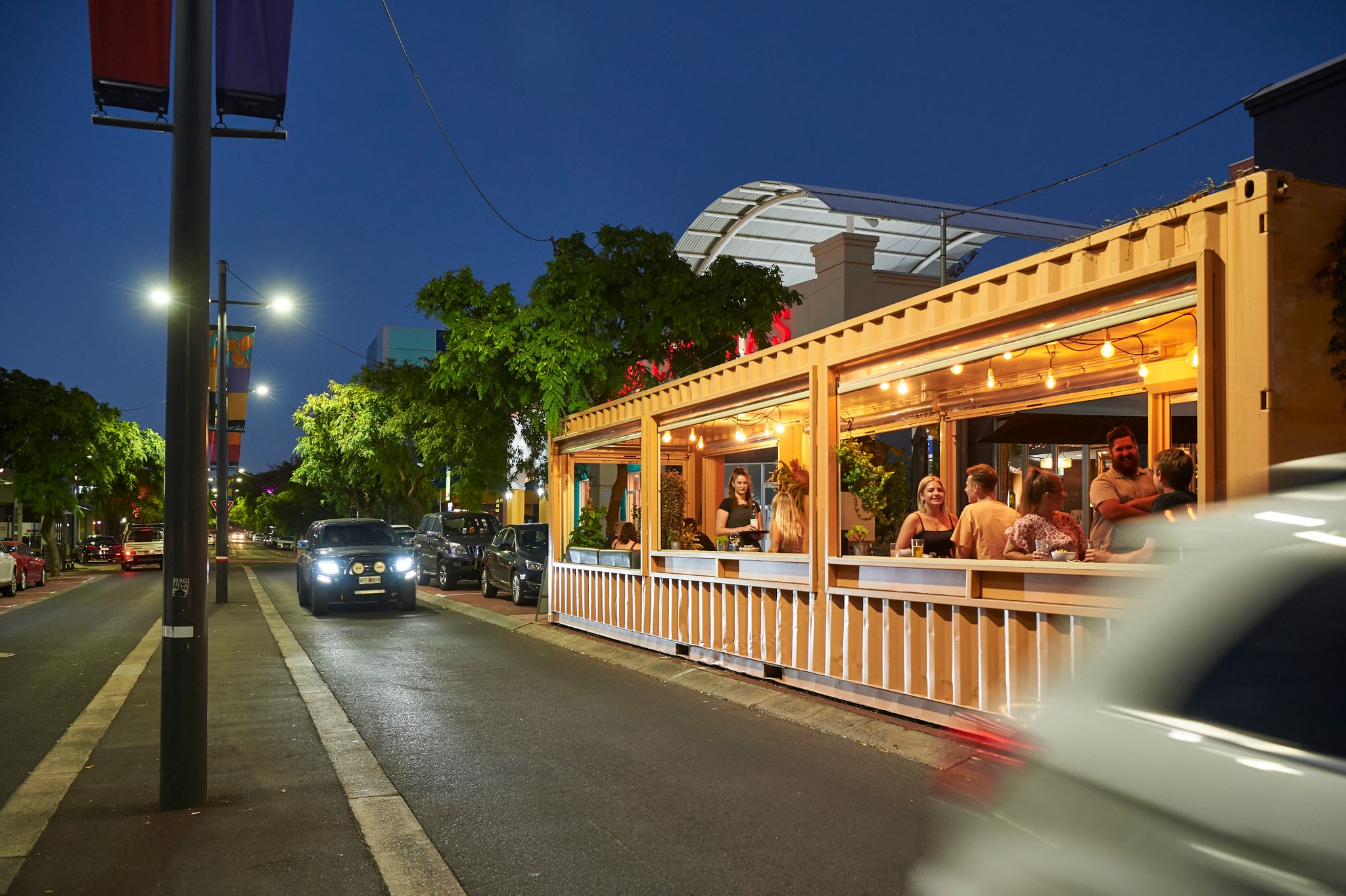 a street and restaurant lit up at night.