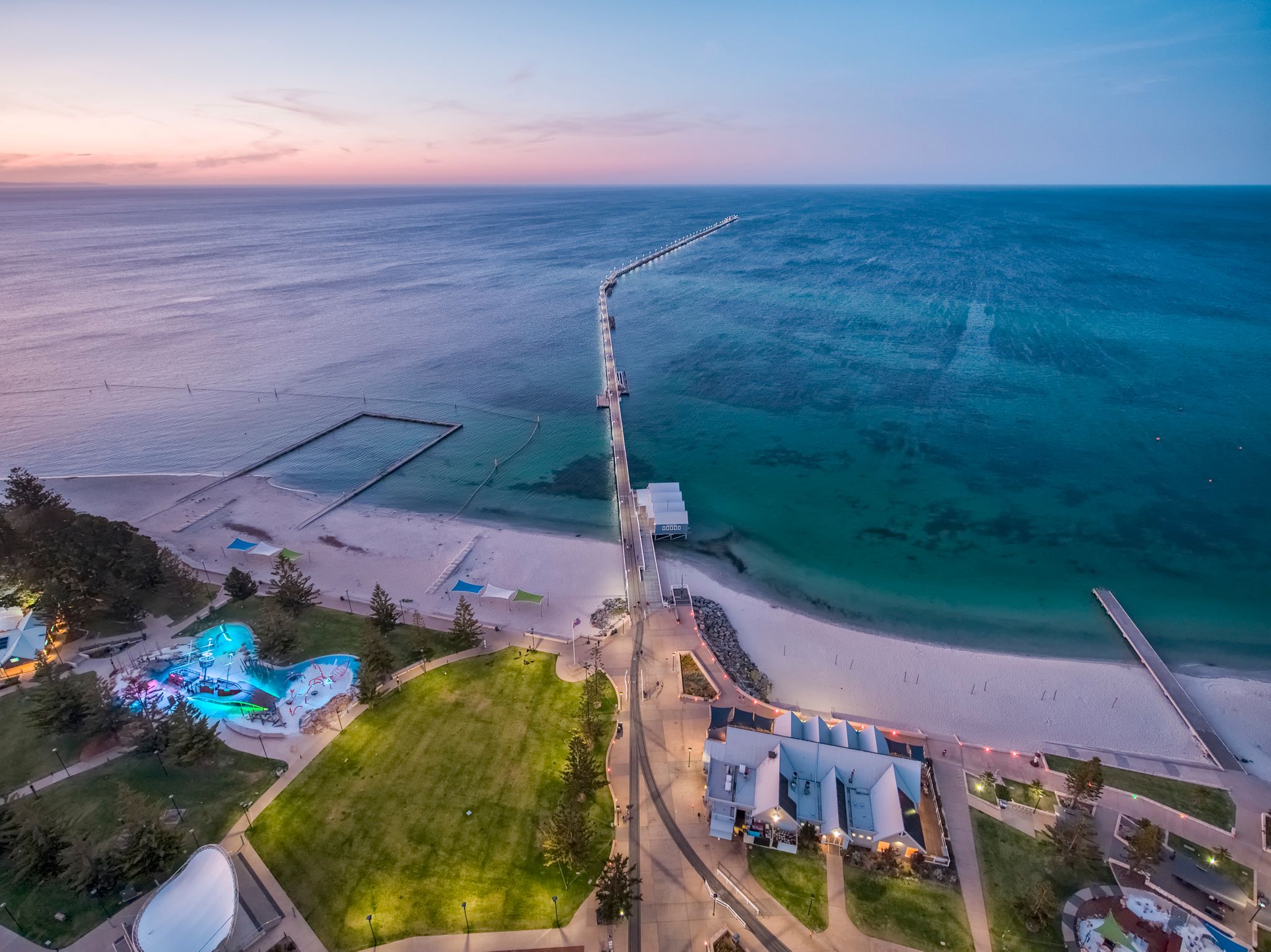 An aerial image of a foreshore, with a jetty leading out to sea.