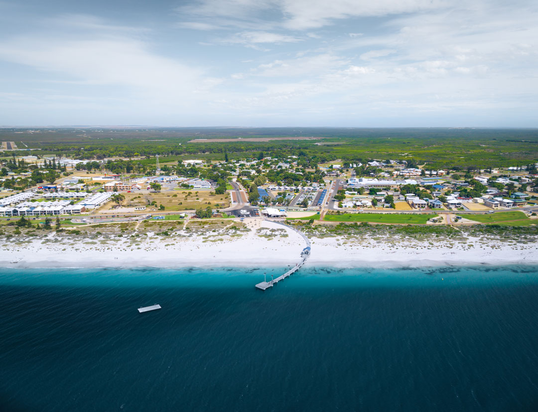 An aerial shot of a jetty stretching out in the water. 