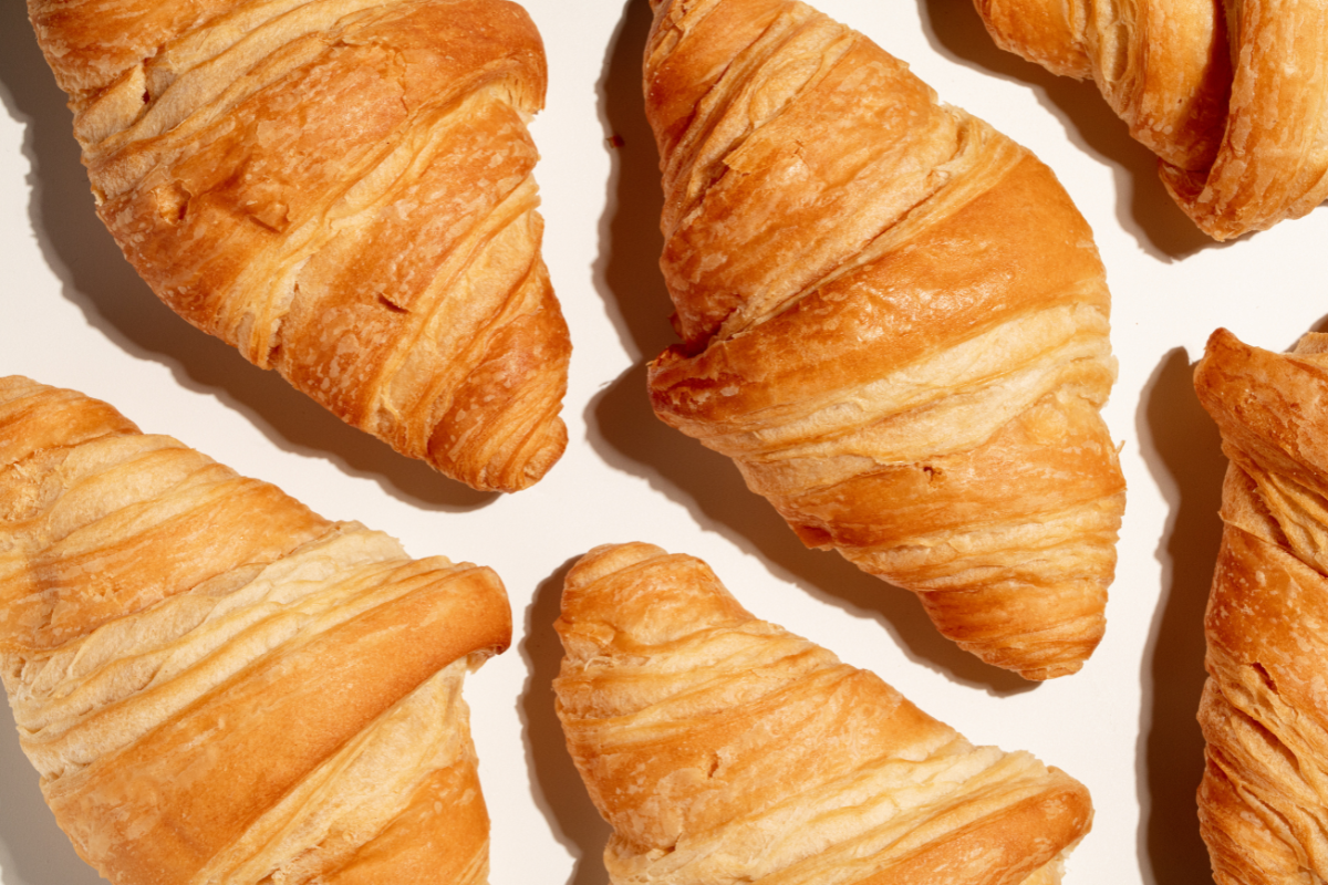 Croissants are laid out on a white background. 